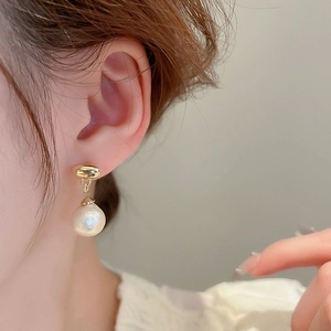 Vintage gold button earrings with hanging white pearl drops shown on model's ear