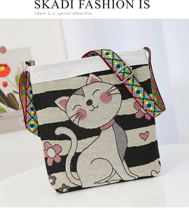 Detail of canvas bag featuring cat embroidery, woven texture, and ethnic strap