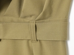 Detailed close-up of woven fabric texture and belt loop stitching on olive jumpsuit