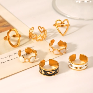 Detailed set of seven gold heart and evil eye rings with white enamel finish