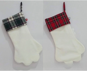 Détail d'une chaussette de Noël en peluche blanche avec motif de patte à carreaux rouges