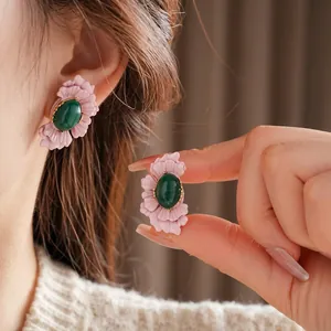 Vintage floral earrings with pink layered petals and emerald green oval gemstone center