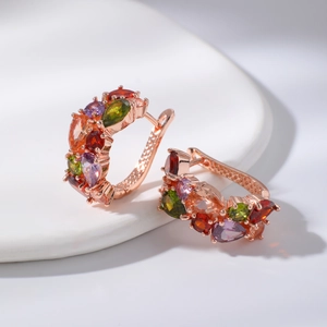Boucles d'oreilles en or rose avec zircones colorées en forme de goutte sur assiette