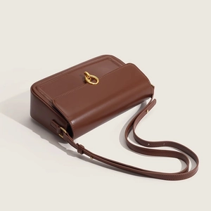Detailed side view of vintage red leather shoulder bag with elegant gold ring hardware