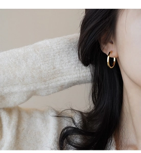 Close-up of minimalist gold hoop earrings worn by a model with elegant styling