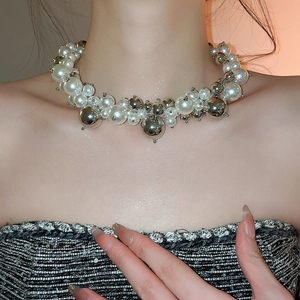 Close-up of mixed faux pearls and polished silver metal spheres on a choker necklace
