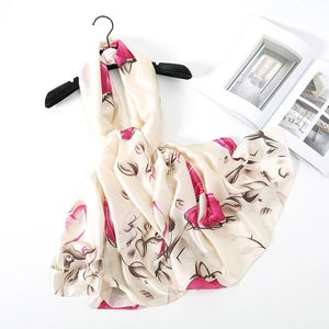 Detail of silk-like champagne scarf featuring elegant rose floral print and satin texture