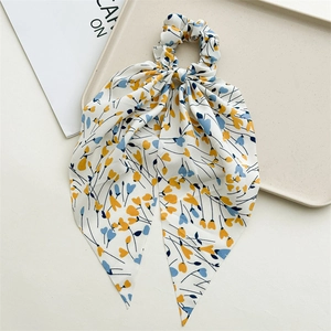 Detail of floral chiffon hair scrunchie with long ribbon on a minimalist tray