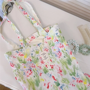 Detailed close-up of a floral canvas tote bag with watercolor prints and fabric label