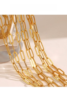 Macro shot of 18K gold plated paperclip chain showing high gloss finish and oval links