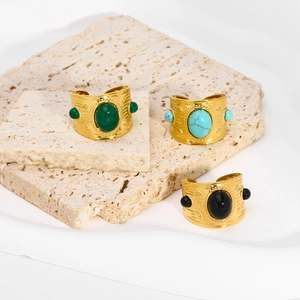 Detailed view of three vintage turquoise rings with gold metal texture and bohemian design