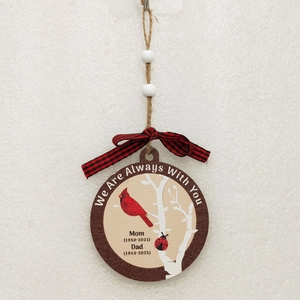 Detail of wooden memorial ornament with cardinal birds, jute rope and checkered bow decoration
