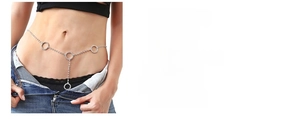 Detailed view of silver rhinestone body chain with heart pendant on model waist