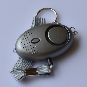 Detail of portable personal safety alarm with LED light and grey braided lanyard