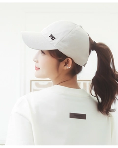 Detail view of white cotton baseball cap with DYY embroidery and high ponytail opening