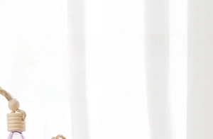 Detail of colorful heart-shaped glass car perfume bottle with wooden cap and string