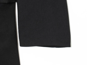 Close-up of the black fabric texture and fine stitching on the stylish panelled dress