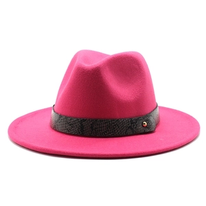 Detail of rose red wool jazz fedora hat featuring snake print band and gold stud accent