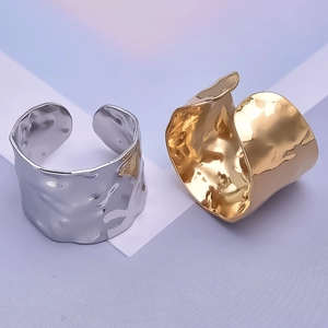 Close-up of gold and silver irregular hammered texture stainless steel open rings