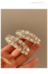 Detailed view of hand-held sparkling rhinestone hair clips with brilliant clear crystals