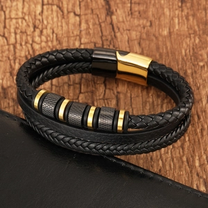 Detail of multi-layer black braided leather bracelet with gold and grey magnetic steel clasp