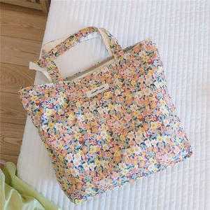 Détail d'un sac en coton à fleurs avec étiquette 'simple wish' sur tissu matelassé