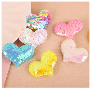 Détail macro de patchs de cœurs en paillettes colorées pour accessoires et artisanat