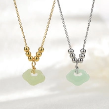 Close-up of gold and silver necklaces with green faux jade ruyi lock pendants