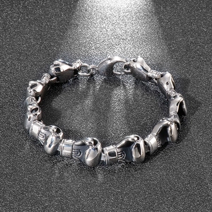 Detailed top view of a masculine silver steel bracelet with boxing glove link charms