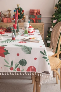 Close-up of Christmas tablecloth with poinsettia patterns and elegant beige tassel fringe
