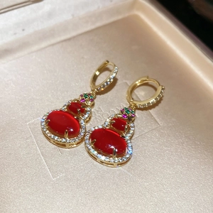 Detailed macro of 14k gold plated gourd earrings with red agate and zircon accents