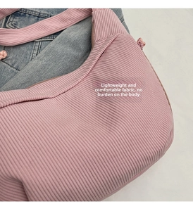 Detail of pink corduroy dumpling bag texture paired with blue denim clothing