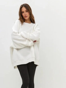 Detail of the soft ribbed crew neck and oversized drop shoulder of the white sweatshirt