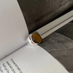 Macro shot of 925 sterling silver tiger eye ring placed on vintage book pages