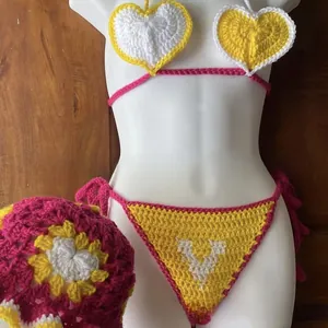 Detail of handmade crochet bikini set with heart patterns and colorful floral knit hat