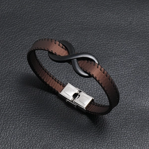 Brown leather bracelet with infinity symbol and stainless steel clasp on leather background