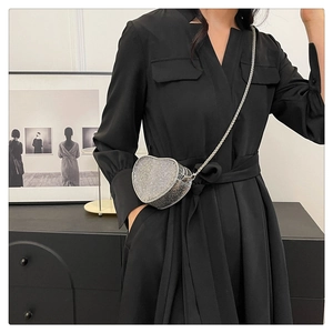 Silver heart-shaped rhinestone mini crossbody bag with metal chain shown on model