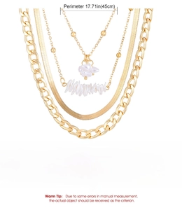 Detail of layered gold alloy necklace featuring irregular pearls and mixed snake chains