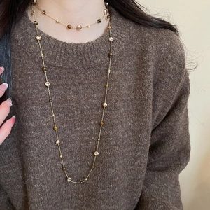 Detail view of multi-layer tiger eye stone beads necklace on dark brown sweater