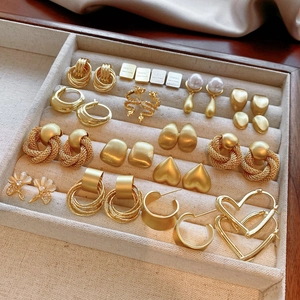 Detailed view of gold vintage earrings collection with pearls and rhinestones on tray