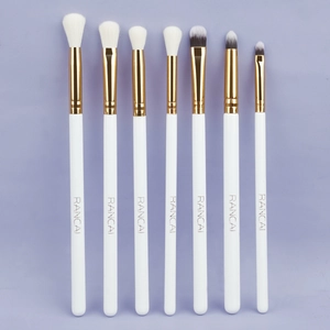 7-piece professional eye makeup brush set with white handles and gold ferrules on purple background
