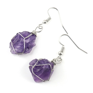 Macro detail of handmade silver wire wrapped raw purple amethyst gemstone earrings