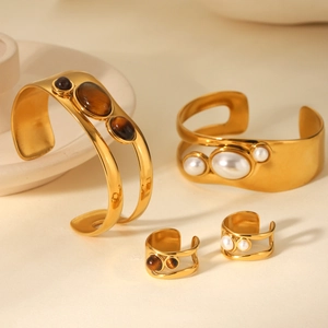 Detailed set of gold stainless steel cuffs and rings with tiger eye and pearls