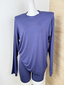 Detail of dark purple long sleeve top and matching biker shorts set on a mannequin