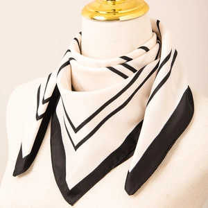 Fashionable black and white striped silk scarf tied on mannequin neck for chic style