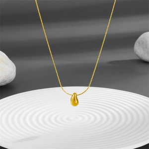 Gold titanium steel droplet necklace with high-polished teardrop pendant on white plate