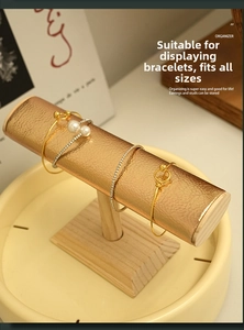 Macro detail of T-bar jewelry stand with rose gold leather texture and wood base