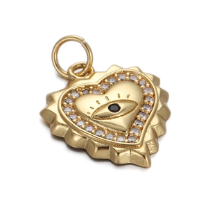 Macro shot of a gold-plated heart pendant with a central eye motif and small clear zircons