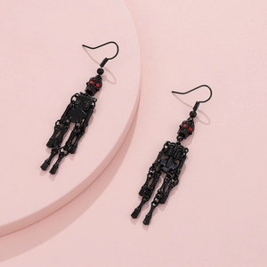 Gothic black skull dangle earrings with red eyes on pink background for Halloween