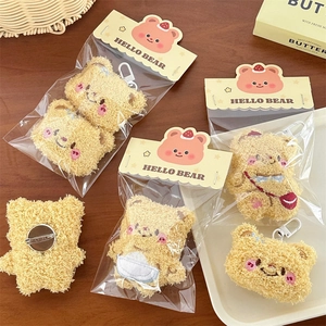 Close-up of yellow plush bear charms and brooches on a rustic wooden table setup